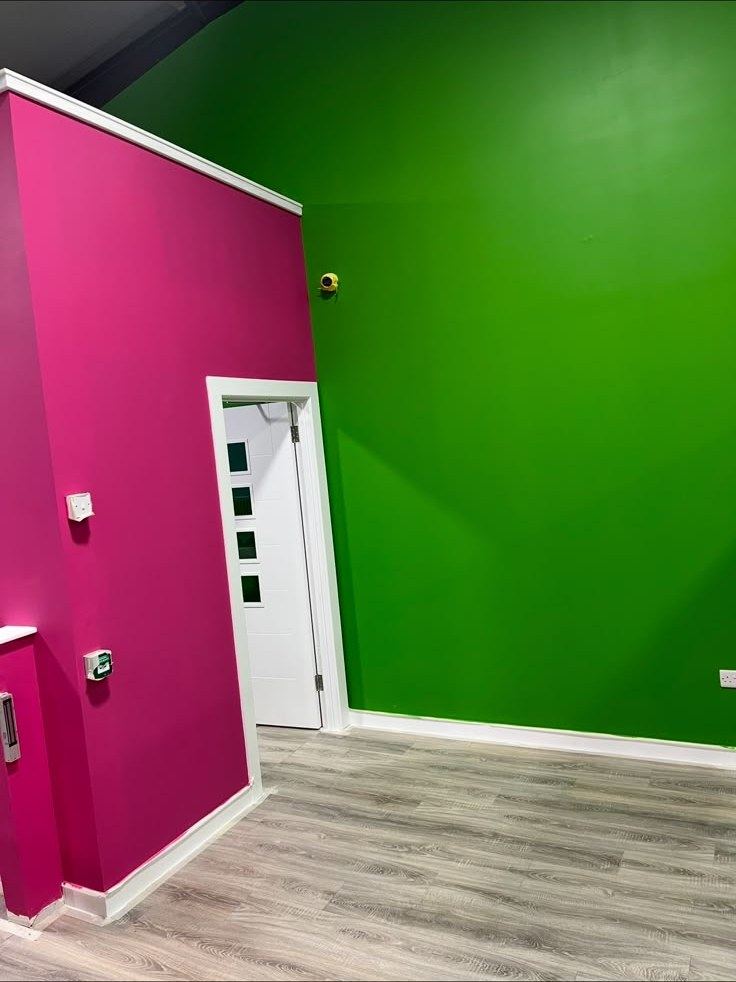 Bold pink and green painted walls in a commercial unit